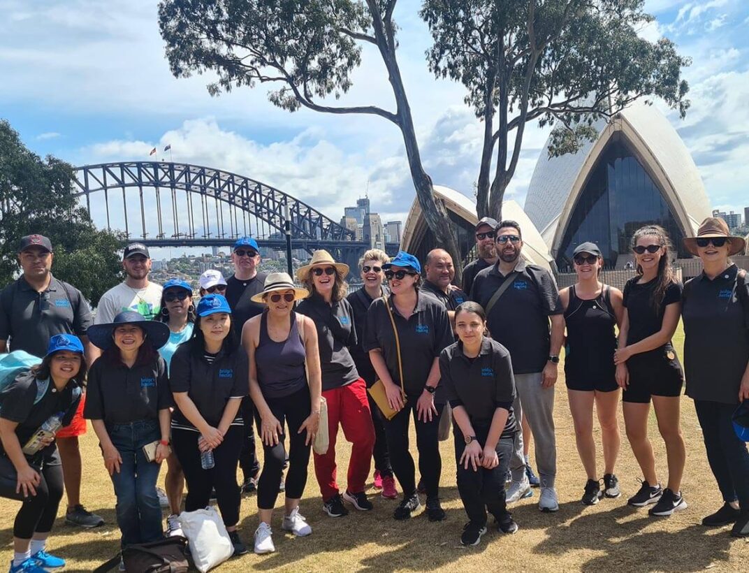 Group posing with Sydney Harbour Bridge and Opera House
